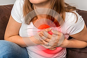 Woman on sofa having heart attack