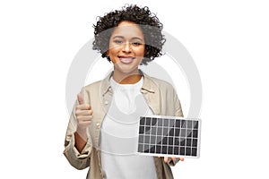 woman with solar battery model showing thumbs up