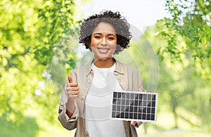 woman with solar battery model showing thumbs up