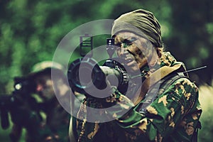 Woman soldier with a grenade launcher in his hands in forest