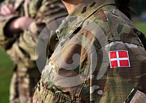 Woman soldier. Woman in army. Flag of Denmark on soldiers arm. Denmark military uniform. Danish troops