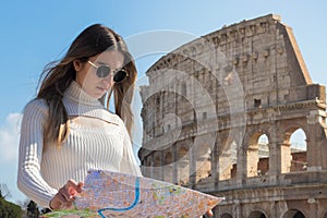 Woman solo traveler looking at the map in the Roman Colosseum in Rome, Italy