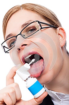 Woman with sore throat using oral spray