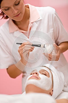 Woman at spa getting facial mask