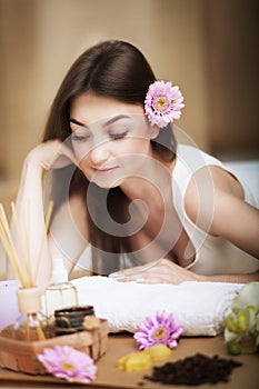 Woman at the spa. Healthy lifestyle and relaxation concept. A beautiful young woman on a massage table. Aroma oil and butter. Spa