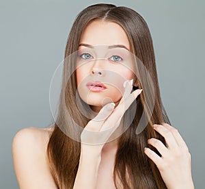 Woman Spa Model Applies a Moisturizer to her Face