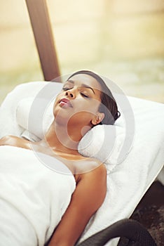 Woman, spa and relax on bed for wellness in Thailand, detox and pamper for self care. Female person, beauty or healing photo
