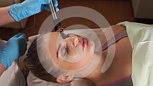 Woman in spa salon, facial rejuvenation procedure. Visit of a beautician.