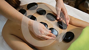 Woman in spa salon with hot stones