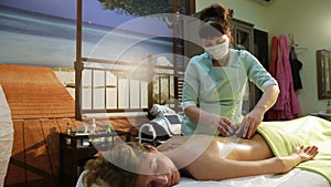 Woman in spa salon with hot stones