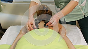 Woman in spa salon with hot stones