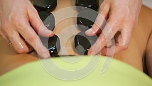 Woman in spa salon with hot stones