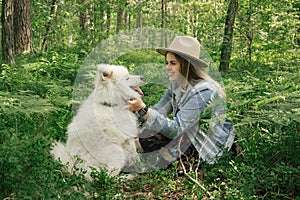 Woman spanding time with her fluffy dog samoyed