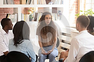 Woman speaking at group counselling therapy session sitting in circle