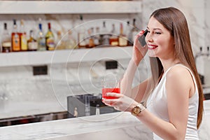 Woman speaks over the phone in bar