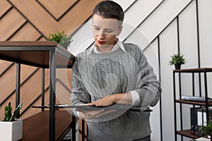 woman specialist stands with papers and documents on the background of the office