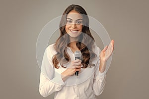 Woman speech, business woman holding a microphone. Happy smiling business woman holding mic, standing with microphone