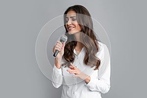 Woman speech, business woman holding a microphone. Stylish girl singing songs with microphone, holding mic at karaoke