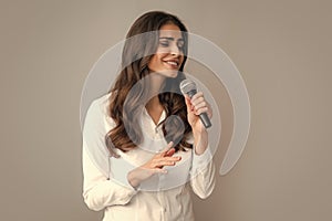 Woman speech, business woman holding a microphone. Stylish girl singing songs with microphone, holding mic at karaoke