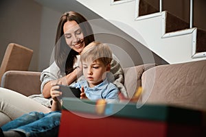 Woman spending New Year Eve with son watching internet content during New Year