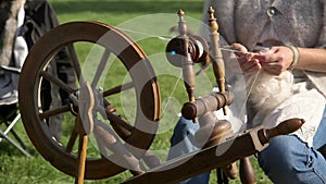 Woman Spins Sheep's Wool with a Spinning Wheel.