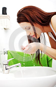 Woman splashing face with water