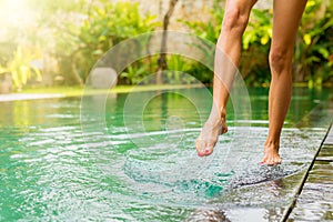 Woman splashing pool water with her leg