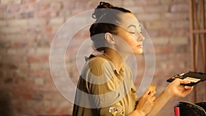 Woman sponging a foundation on her face