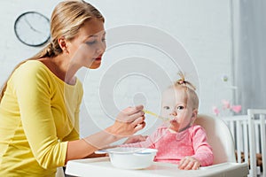 Woman spoon of baby food while