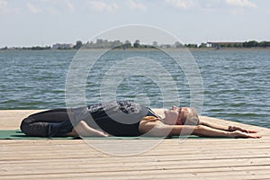 Woman with sport bra doing yoga fitness exercise for relax and healthy at lake in morning, Nature background, Concept outdoor