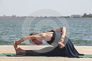 Woman with sport bra doing yoga fitness exercise for relax and healthy at lake in morning, Nature background, Concept outdoor