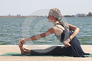 Woman with sport bra doing yoga fitness exercise for relax and healthy at lake in morning, Nature background, Concept outdoor