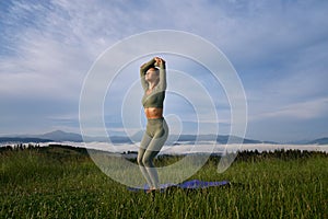 Woman in sport clothes doing yoga exercises on nature