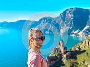 Woman in sport outfit enjoying scenic view from hiking trail between Positano and Praiano at the Amalfi Coast, Italy, Europe