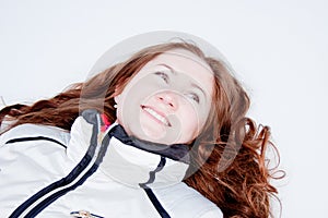 Woman in a sporting suit lies on to snow