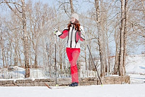 Woman in a sporting suit on skis in-field