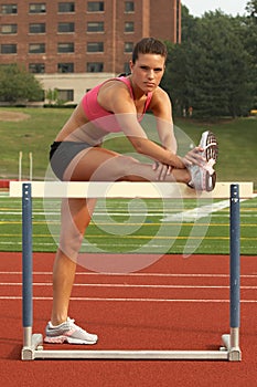 Woman in Sports Bra and Shorts Stretching Hamstring on Hurdle