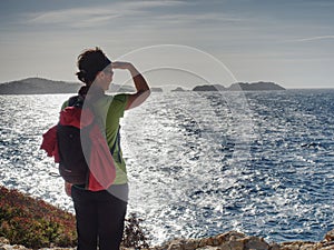 Woman in sports clothes shadowing eyes  at sea