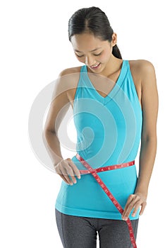 Woman In Sports Clothing Measuring Her Waist
