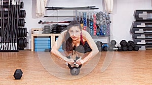 Woman sports push up on kettlebell