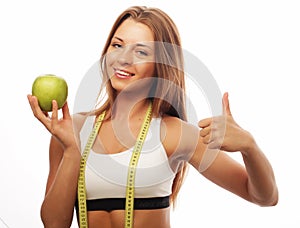 Woman in sports wear with green apple on white background