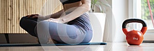 Woman in sportsclothing sitting in lotus position