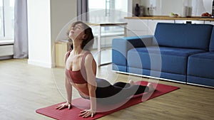 Woman in sportswear doing cow cat pose, exercises on mat