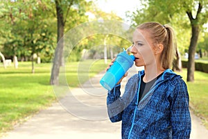 Woman in sportswear drinking protein shake