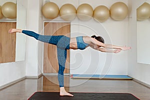 Woman in sportswear in the gym doing a balance exercise swallow
