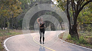 Woman in sportswear jogging or running outdoors on a sunny day in the summer evening.