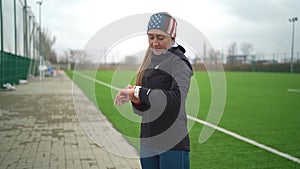 Woman in sportswear looking at fitness bracelet