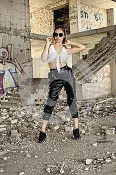 Woman in sporty clothes posing at abandoned construction site