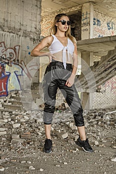 Woman in sporty clothes posing at abandoned construction site