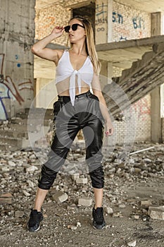 Woman in sporty clothes posing at abandoned construction site